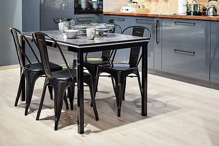 black dining table with 4 chairs near blue cabinetry thumbnail