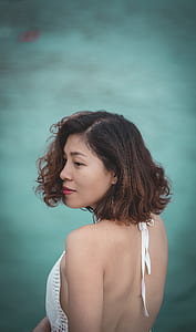 shallow focus photography of woman standing near body of water thumbnail