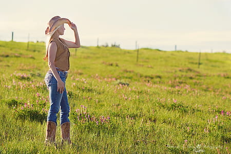 Woman Wearing Brown Cowboy Boots and Vest With Hat Under Blue Sky during Daytime thumbnail