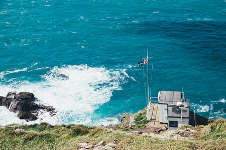 gray building with flags near ocean at daytime thumbnail
