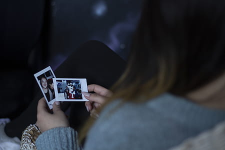 Woman Holding Two Photos thumbnail