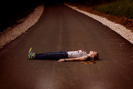 woman laying on empty road thumbnail