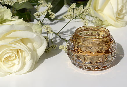 white rose and baby's breath flowers beside a crystal candle holder thumbnail