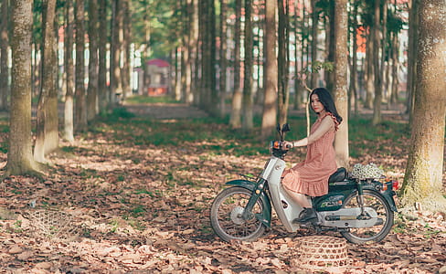 Woman Riding Underbone Motorcycle Between Trees thumbnail