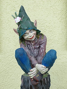 dwarf sitting on stump statue near yellow wall thumbnail
