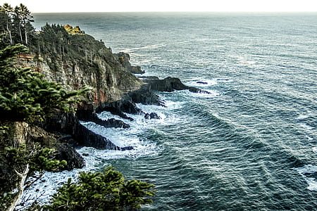 aerial photography of ocean wave on rock formation at daytime thumbnail