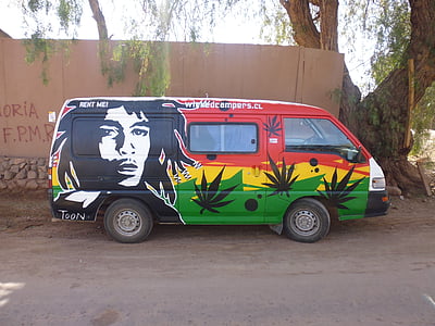 red, yellow, and green van parked on brown road thumbnail