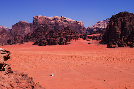 desert near rocky mountain under blue sky thumbnail