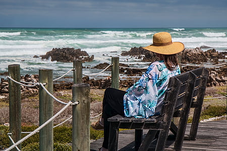 person wearing brown hat while seating on brown wooden chair thumbnail