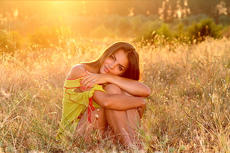woman in yellow dress sitting on green grass during daytime thumbnail