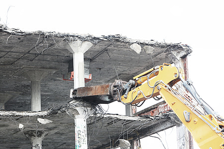 yellow heavy equipment wrecking building during daytime thumbnail