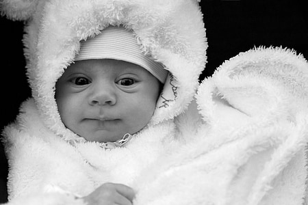 grayscale photo of baby wearing white comforter thumbnail