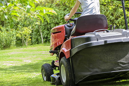 person riding red riding mower during daytime thumbnail