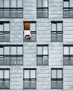 white bed comforter hanging on an opened apartment window thumbnail