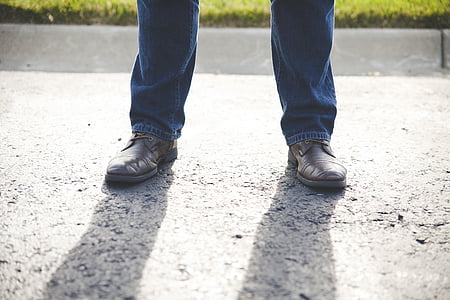 person wearing blue denim jeans and black shoes standing thumbnail