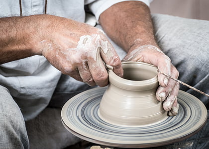 person in gray shirt and gray pants molding clay pot thumbnail