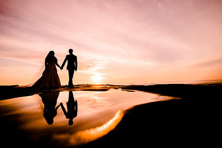 silhouette photography of couple walking near body of water thumbnail