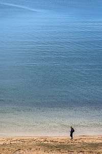 person walking near body of water thumbnail