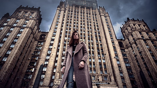HRD photography of woman standing in front of high-rise building during daytime thumbnail