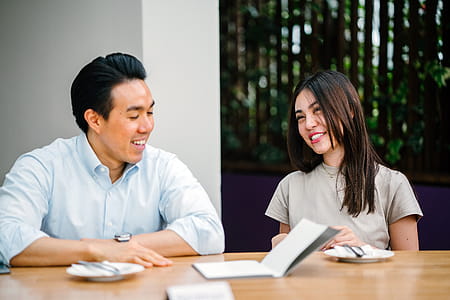 Man and Woman Sitting on Chair in Front of Desk thumbnail