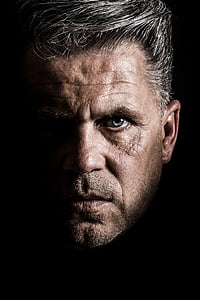 close-up of a man's face against black background thumbnail