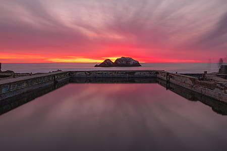 rock formation surrounded by body of water thumbnail