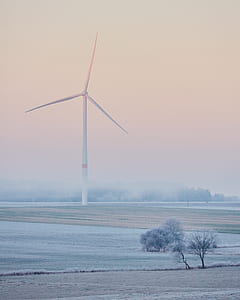 white windmill on field under pink sky thumbnail
