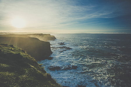 cliff beside body of water during daytime thumbnail