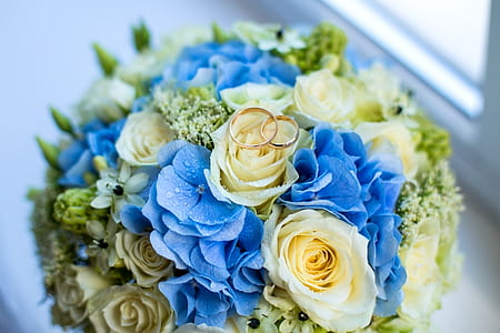 two gold-colored rings on roses and hydrangeas bouquet thumbnail