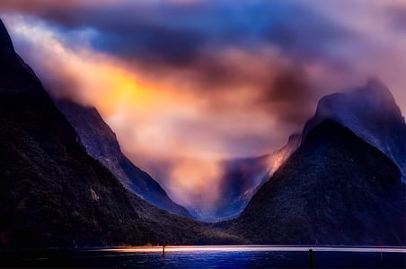 mountains near body of water water under cloudy sky thumbnail