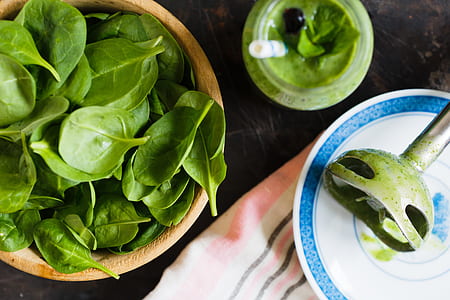 top view of spinach in brown bowl and clear glass jar thumbnail