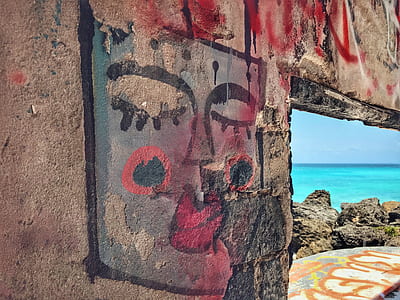 woman's portrait painting on wall near sea thumbnail