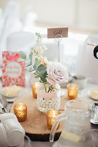 pink rose flower in clear glass jar beside tealight candles thumbnail
