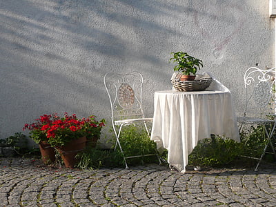 white wrought iron 3-piece patio set near red petaled flowers thumbnail