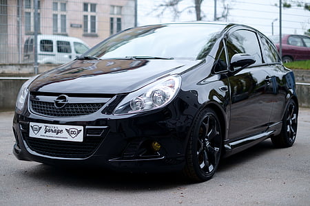 black Opel sedan parked on gray concrete surface thumbnail