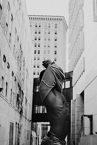 grayscale photography of man taking off his sweater thumbnail