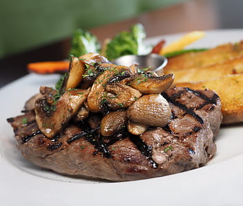 brown steak with mushroom toppings on white ceramic plate thumbnail