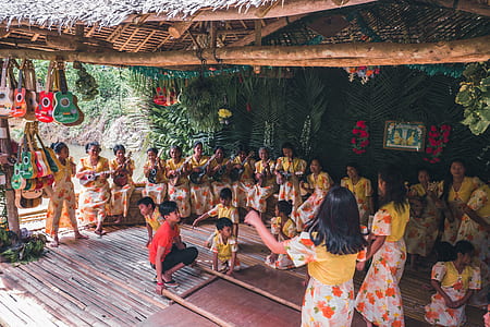group of women sitting while playing instrument in front of children playing folk dance thumbnail