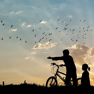 photo of boy and child holding bicycle during daytime thumbnail