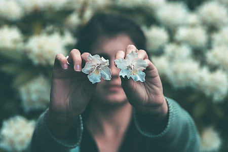 woman holding teal petaled flowers thumbnail