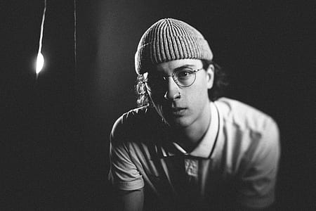 grayscale photo of man wearing beanie cap and polo shirt thumbnail