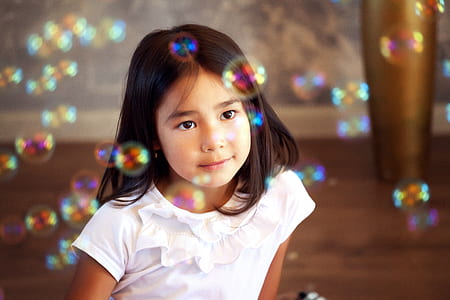tilt shift lens photography of girl wearing white crew-neck shirt thumbnail