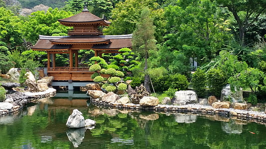 brown wooden gazebo near trees and pond thumbnail