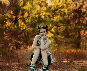 sitting woman wearing white and black sleeveless top thumbnail