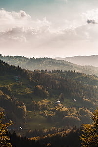 aerial photography of green field and mountains under white clouds thumbnail