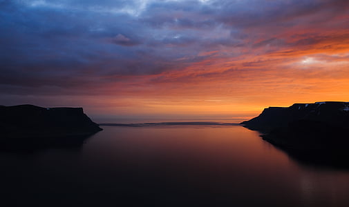 body of water surrounded by mountains thumbnail