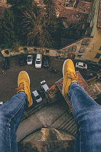 person sitting on edge of building during daytime thumbnail