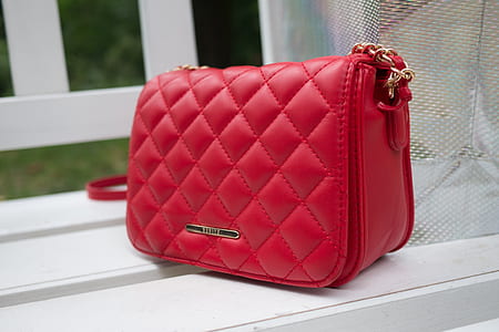 quilted red leather flap bag on wooden chair thumbnail
