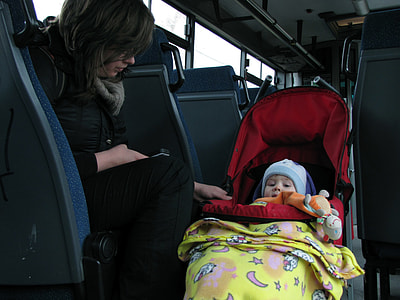 woman sitting on bus chair beside toddler on stroller thumbnail