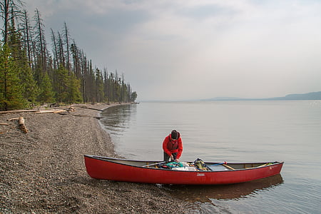 woman standing beside red canoe thumbnail